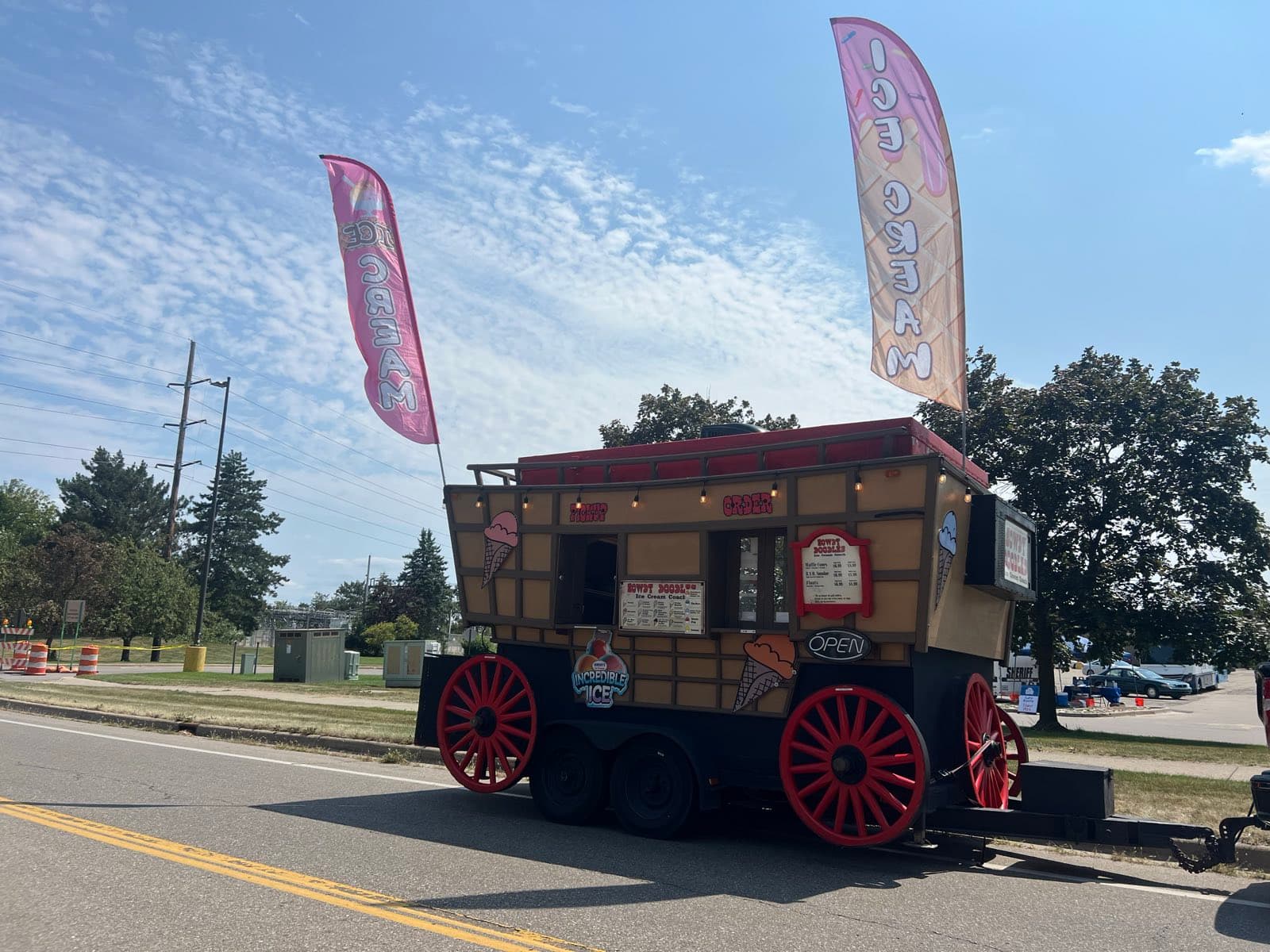 The Howdy Doodles ice cream coach — a stagecoach with red spoked wheels and painted menu boards, flags flying
